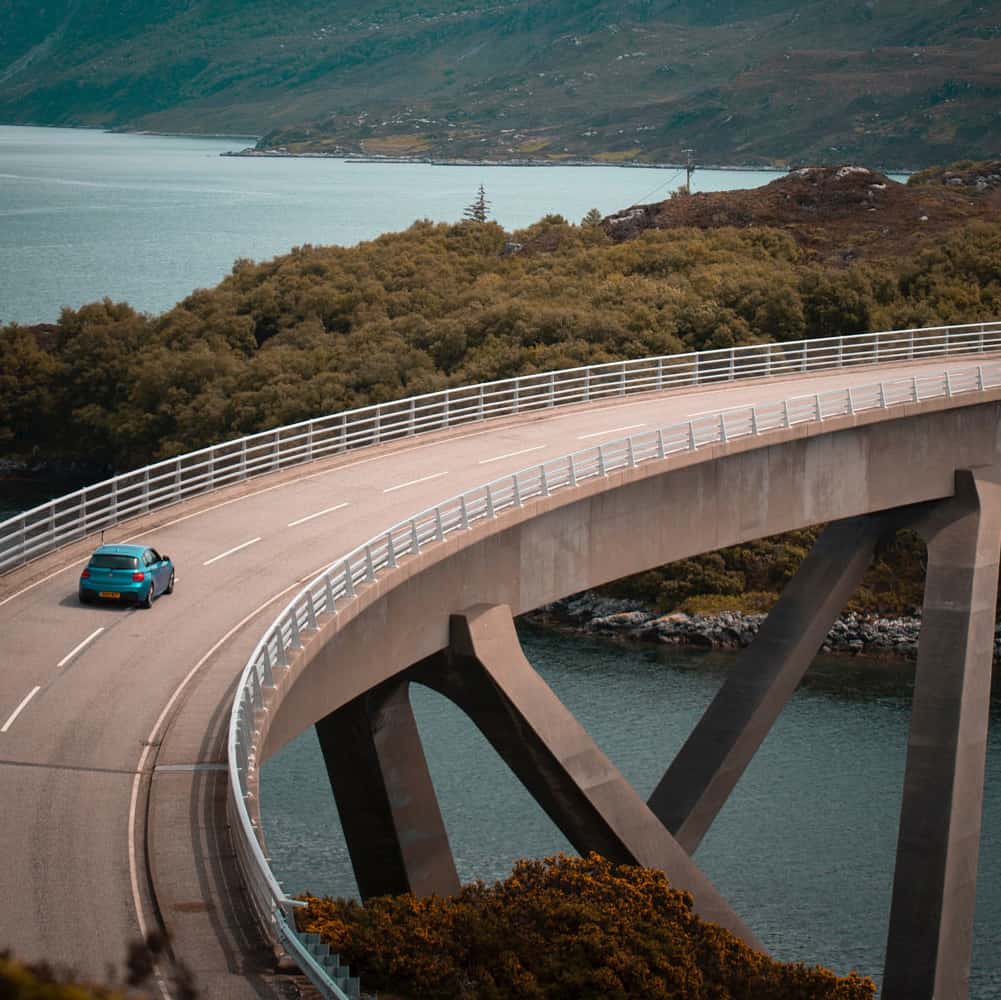 Car driving along bridge highway over water