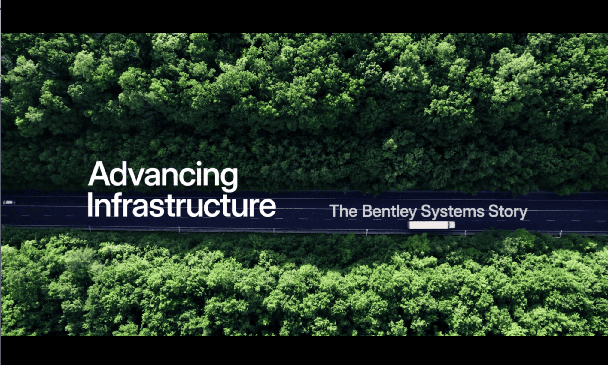 Aerial view of a roadway cutting through a forest with the text "Advancing Infrastructure: The Bentley Systems Story" written across the image, celebrating 40 years as a pioneering software company.