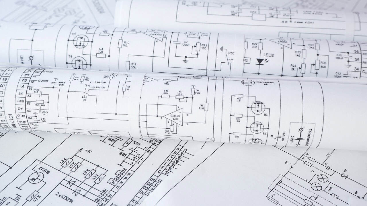 Rolled and flat sheets of technical diagrams display various electronic circuit schematics and component symbols, illustrating the evolving role of AI in infrastructure engineering.