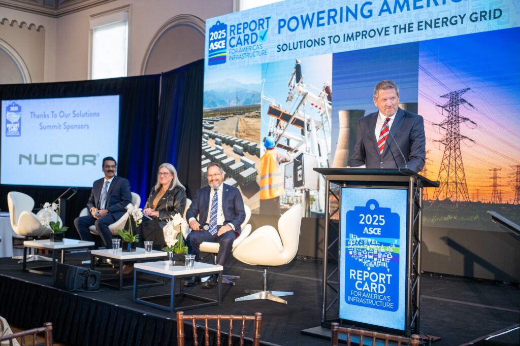 A speaker presents at a 2025 ASCE event on improving the energy grid, with four seated panelists and a backdrop featuring energy infrastructure images.