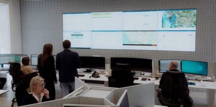 Inside look of AE Porto offices. People studying a wall of monitors depicting AE Porto's digital twin of their water network.