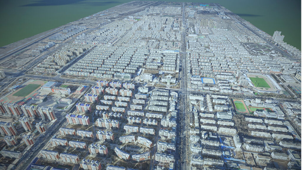 Aerial view of a densely built urban area in Northwest China with grid-patterned streets, numerous apartment buildings, sports fields, and a large body of water in the background showcasing smart flood control and digital innovation.