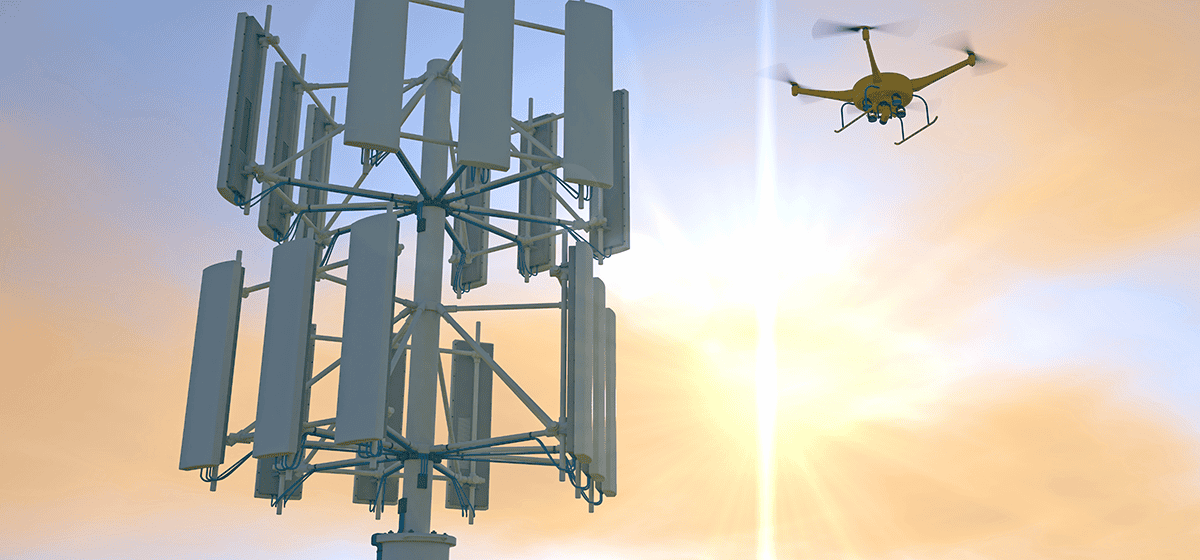 A drone hovers near a telecommunications tower with multiple antennas against a backdrop of a sunrise or sunset sky, playing a crucial role in industry efforts towards efficient tower lifecycle management.