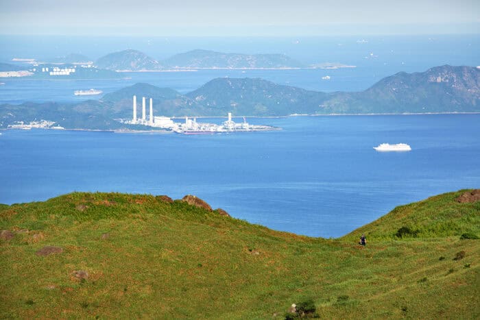 A hilly green landscape in the foreground overlooks the Pearl River Delta.