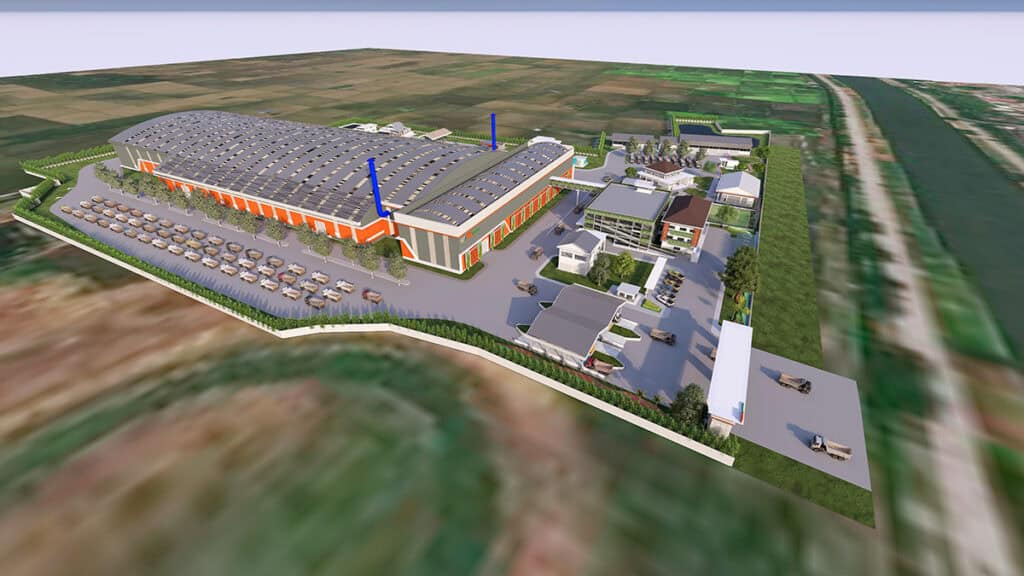Aerial view of the PT Wijaya Karya YII Project industrial facility, showcasing a large warehouse, several smaller buildings, parked cars, and surrounding greenery near fields and a canal, supporting refuse-derived fuel operations.