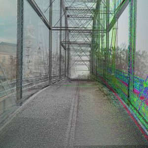 A steel bridge is shown with its left side in full color while the right side, created using Digital Twins technology, is rendered as a digital point cloud with green, red, and blue highlights.