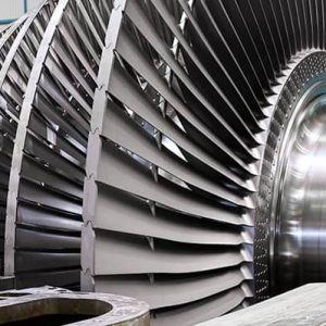 Close-up view of large metallic turbine blades and rotor components inside an industrial facility, showcasing Nippoh Engineering’s commitment to carbon-neutral design for a sustainable future.