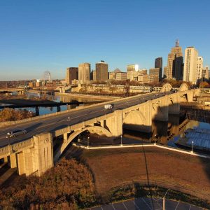 Aerial view of vehicles crossing the Robert Street Bridge, set against a backdrop of skyscrapers under a clear blue sky in St. Paul, Minnesota.