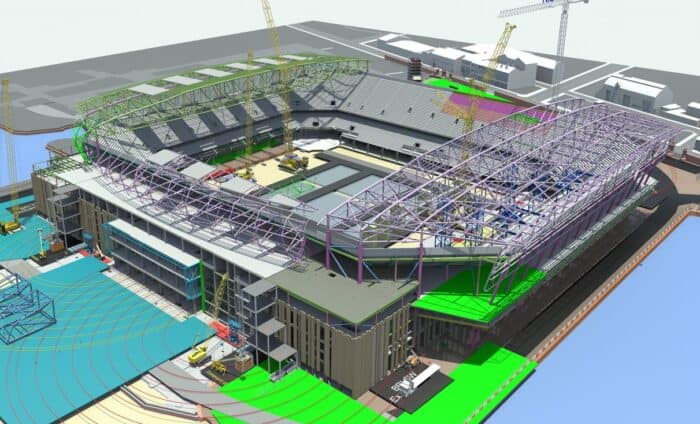 A digital rendering of a stadium under construction, featuring cranes, a partially covered seating area, and surrounding infrastructure.