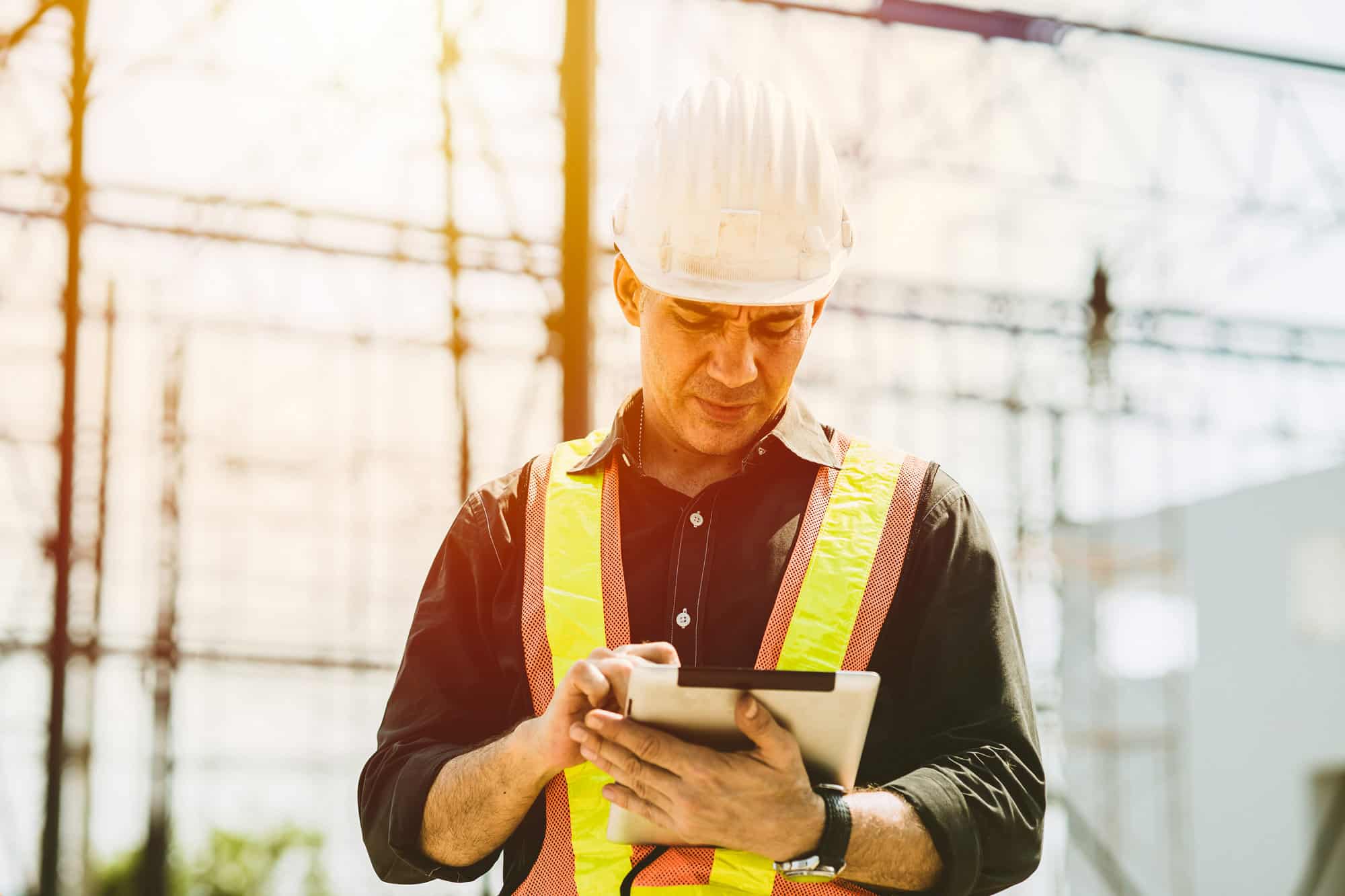 Construction Worker Looking at Tablet