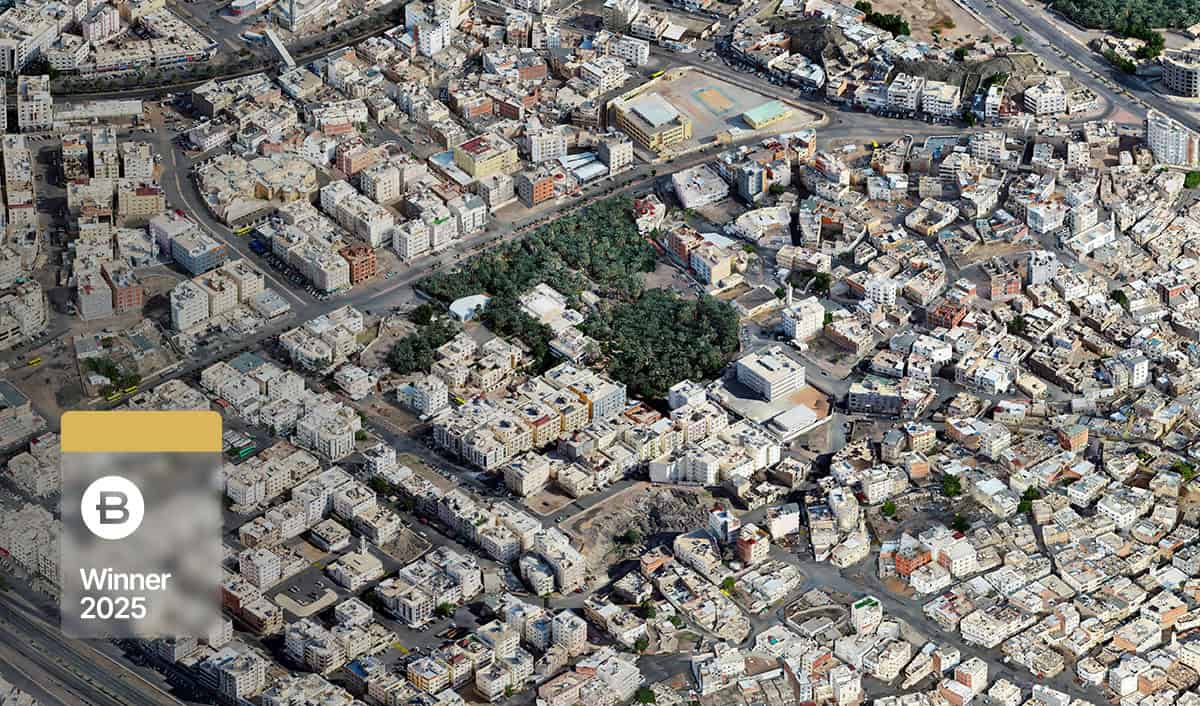 Aerial view of a densely built urban area in the Madinah smart city, with roads, buildings, and a patch of greenery; an overlay displays "B Winner 2025" in the bottom left corner.