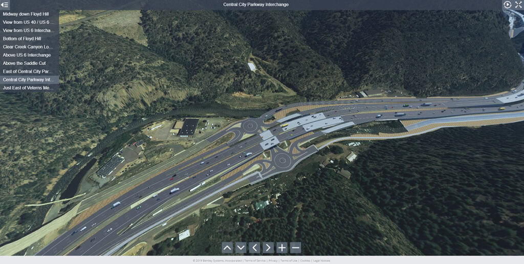 Aerial view of a large highway interchange with multiple lanes, overpasses, and roundabouts surrounded by trees and hills—showcasing tomorrow’s roads shaped by advanced roads technology.