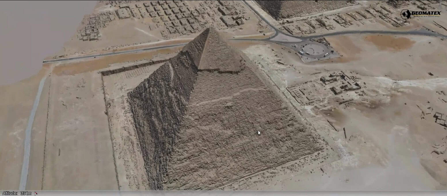 Aerial view of the Great Pyramid of Giza in Egypt, surrounded by smaller pyramids, ancient ruins, and nearby roads.