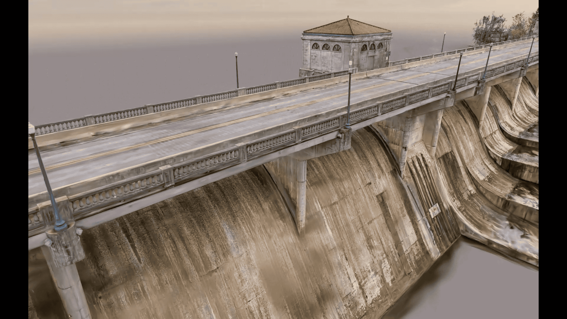 A concrete bridge with a red-roofed building spans over a dam, with water visible at the base and a cloudy sky in the background.