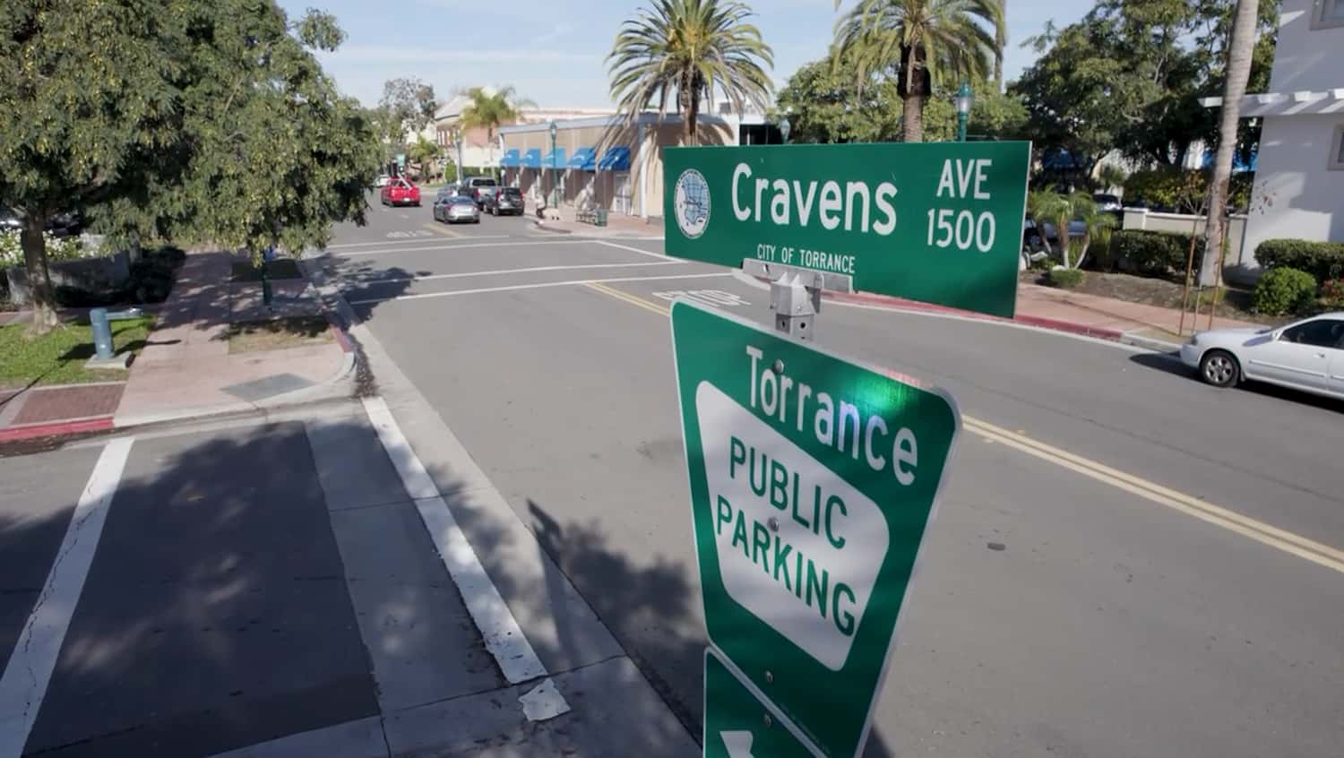 Cravens Avenue street sign sits above a Torrance Public Parking direction sign.