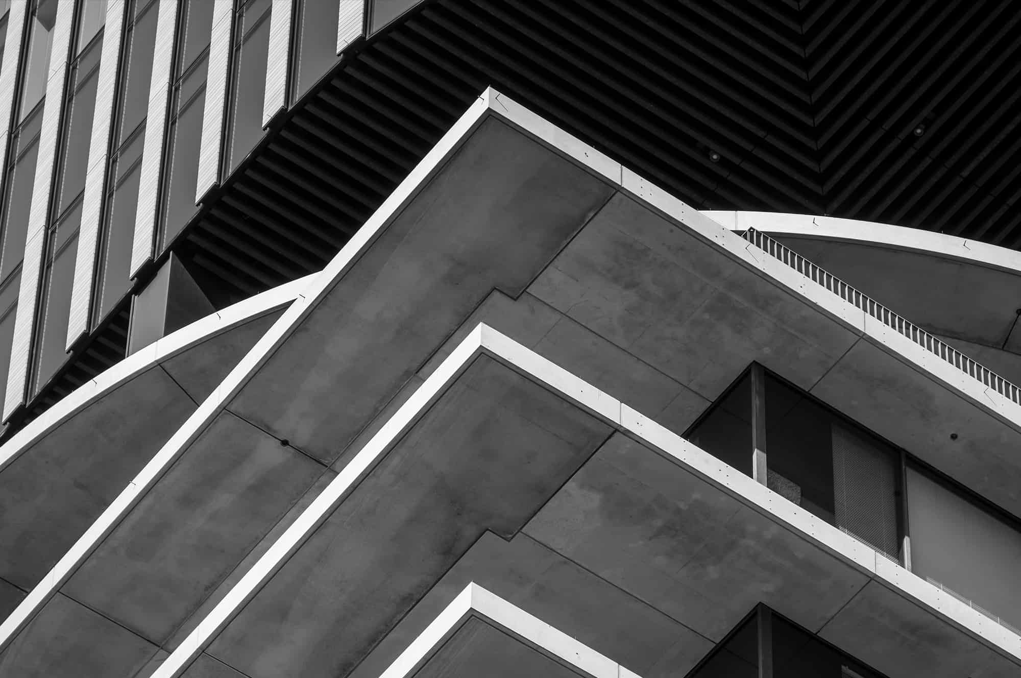 Monochrome image of a modern building showcasing angular architectural details and contrasting textures.