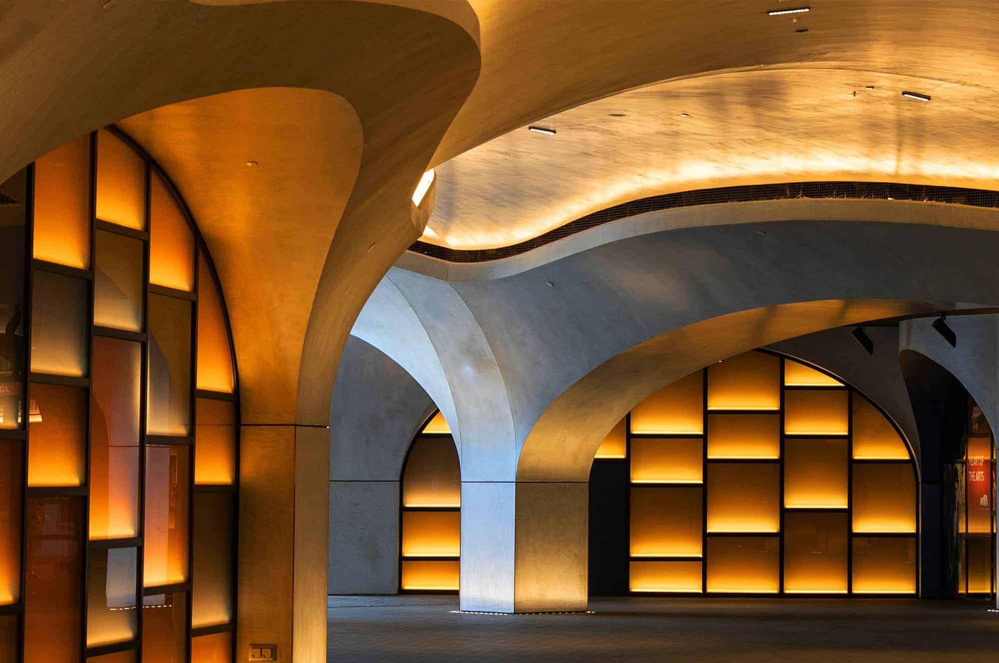 An illuminated modern interior with curved architecture and warm lighting.
