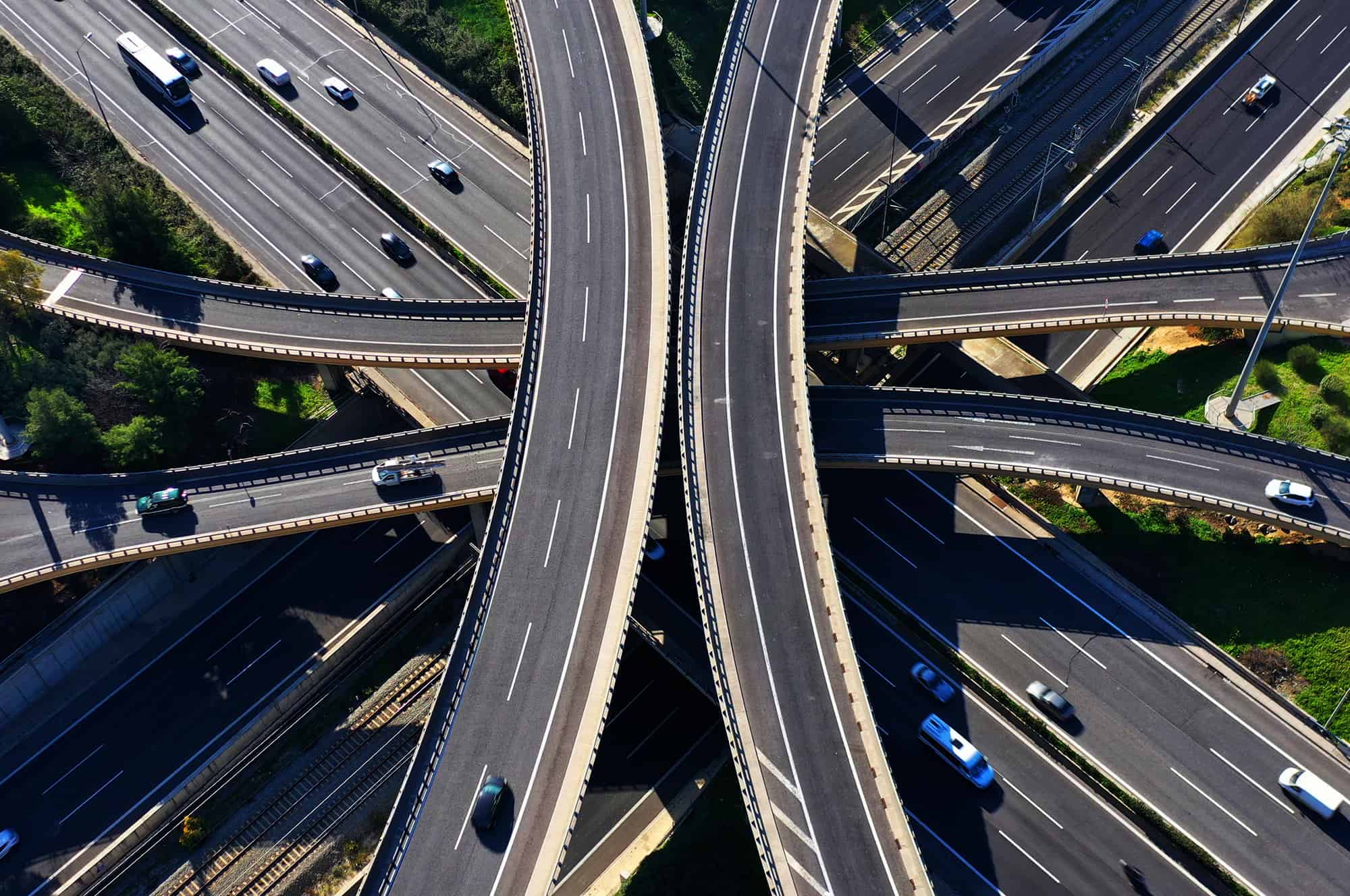 Aerial view of a multi-level highway interchange with cars and trucks.