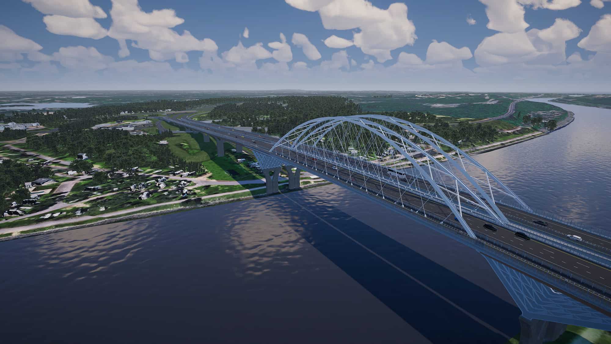 A large steel arch bridge spans a wide river, connecting two areas of green landscape under a partly cloudy sky. Vehicles are visible traveling across the bridge.