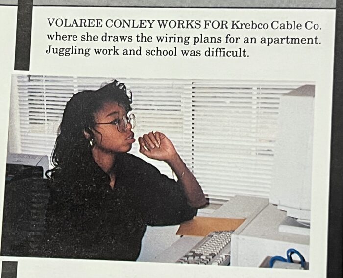 A woman sits at a desk, looking at a computer monitor, with her hand on her chin and papers nearby. Text above describes her job and the challenge of balancing work and school.
