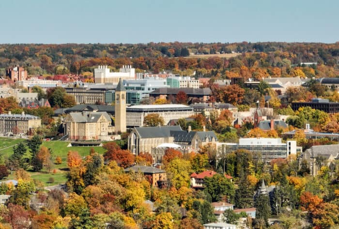 Scenic view of a sprawling campus with historic buildings amidst vibrant autumn foliage.