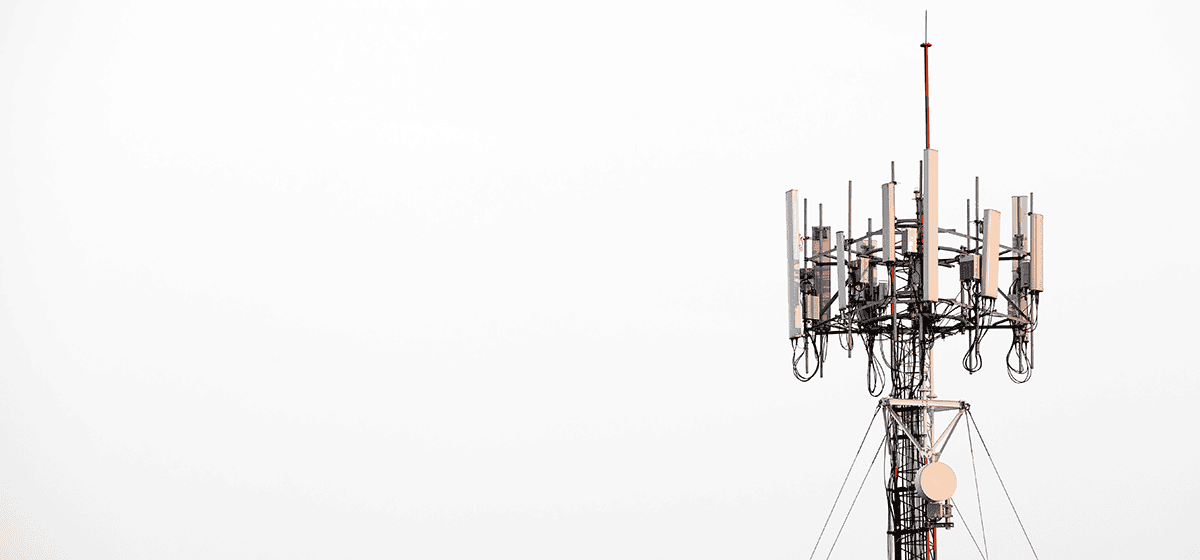 A tall telecommunications tower with multiple antennas and dishes against a plain white background, showcasing the advanced capabilities of OpenTower iQ for improved data accuracy through its digital twin technology.