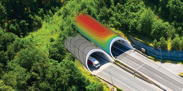 Aerial view of a roadway tunnel with two entrances; one entrance is covered by green vegetation, the other has a digitally overlaid heatmap gradient.