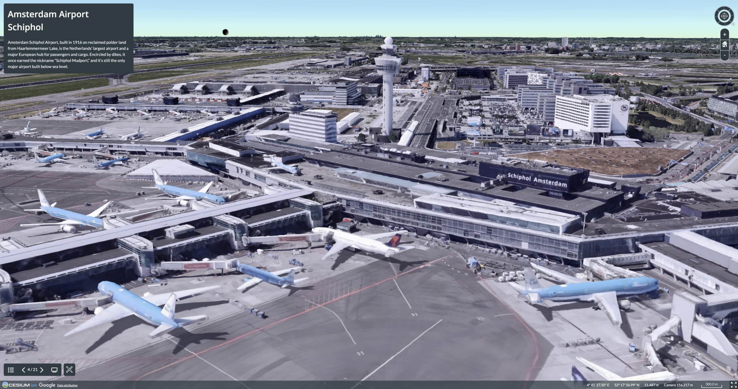 Aerial 3D view of Amsterdam Airport Schiphol in the Netherlands, showing multiple airplanes at gates, terminal buildings, and the control tower near the sea in the background.