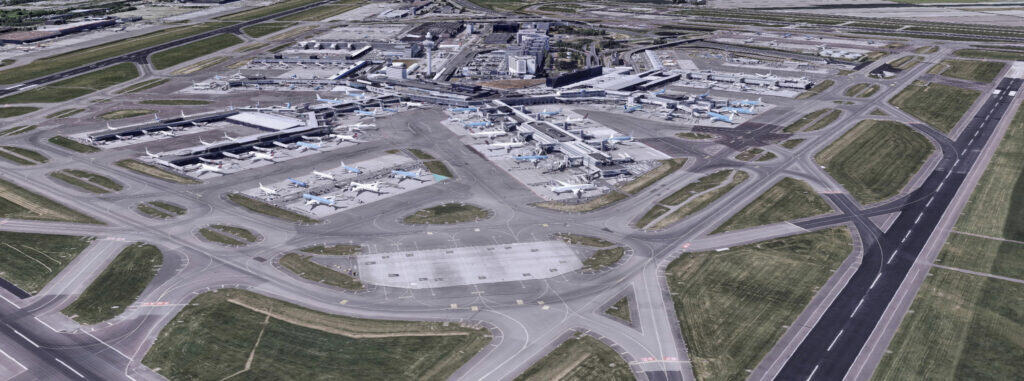 Aerial 3D view of a large airport terminal in the Netherlands, with airplanes parked at gates and surrounded by runways, taxiways, and grassy areas near the sea.