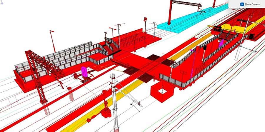 3D digital model of a train station platform with overhead lines, tracks, staircases, and pedestrian bridges in red, yellow, and blue.