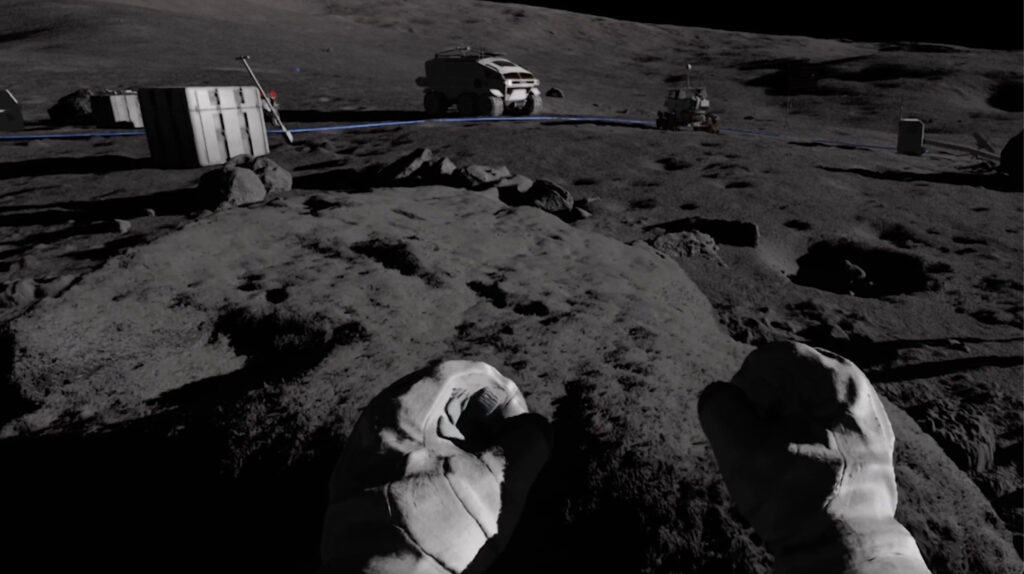 A person in a spacesuit stands on a rocky lunar surface near equipment, a portable habitat, and a vehicle under dark sky conditions.