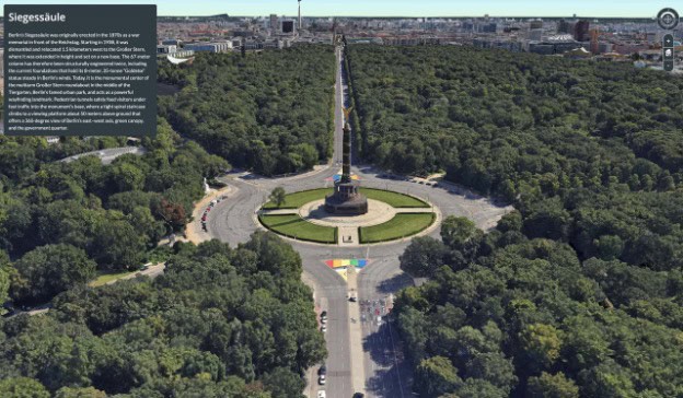 Aerial view of the SiegessƤule (Victory Column) in Berlin, Germany, surrounded by a large circular road and dense green trees, with city buildings visible in the distance.