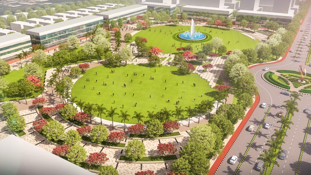 Aerial view of a large urban park at Atal Puram Township, featuring a central green lawn, fountain, walking paths, lush trees, and surrounding roads with traffic—crafted using advanced design tools by Voyants Solutions.