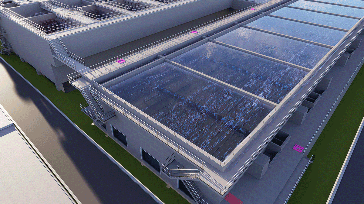 Aerial view of a modern water treatment facility showing large open tanks with clear water, surrounded by concrete structures and metal railings.
